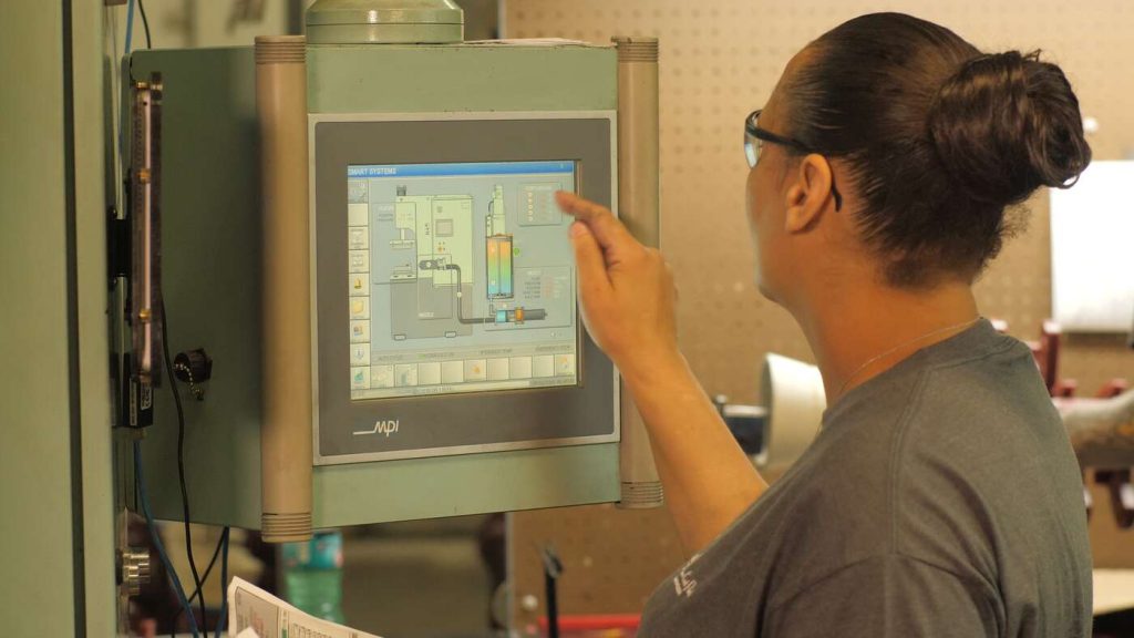 Team member on wax machine control panel