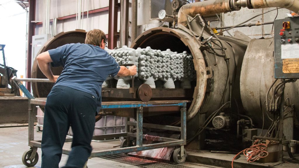 Dewaxing: operator inserts molds into an autoclave for dewaxing